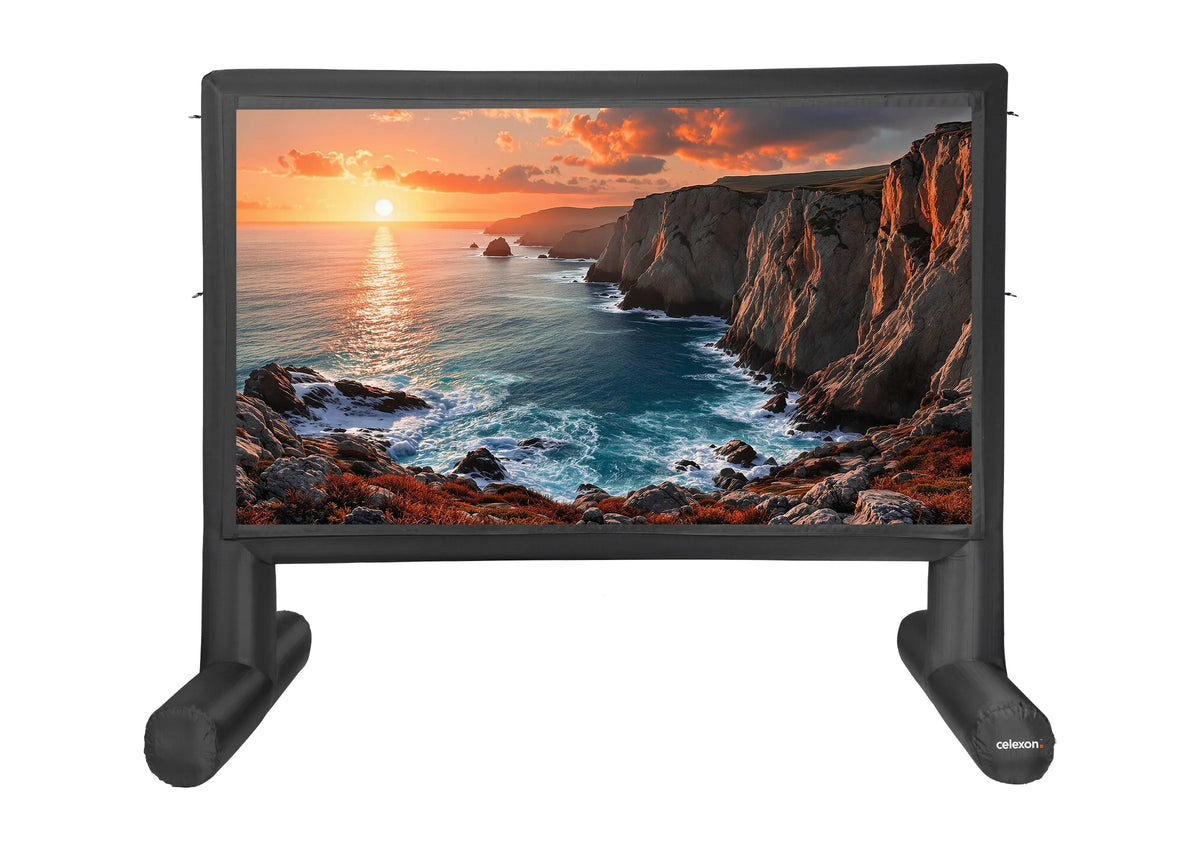 Frontal view of the celexon inflatable outdoor projection screen Professional INF with a projection of a Sunset on the coast