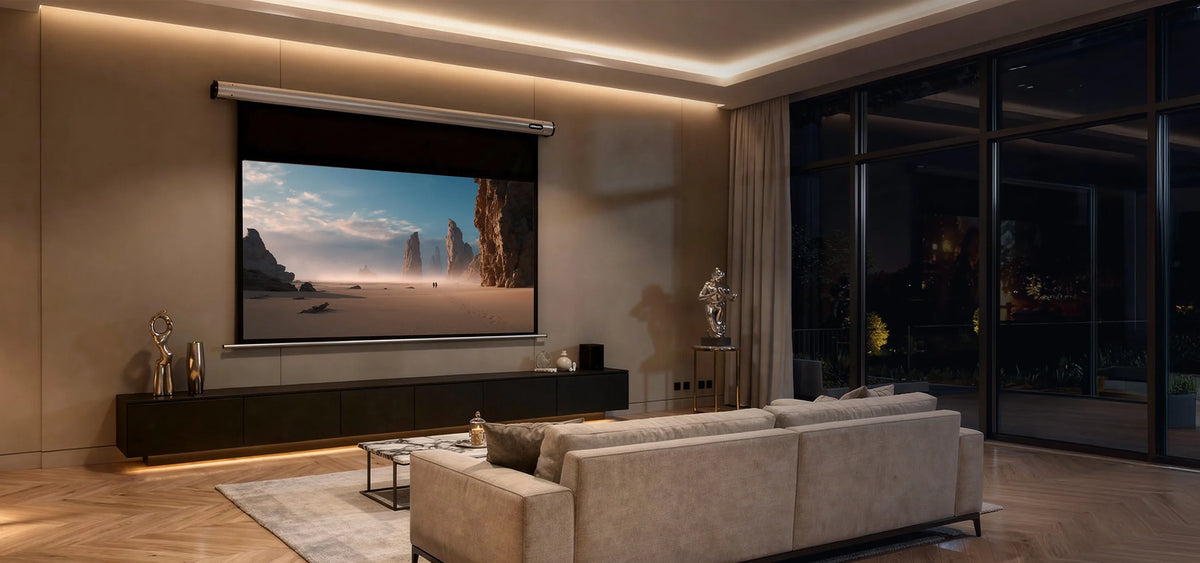 The image shows a modern, darkened living room with a celexon Projector Screen Electric HomeCinema, displaying a calm desert landscape, complemented by stylish furniture and indirect lighting.