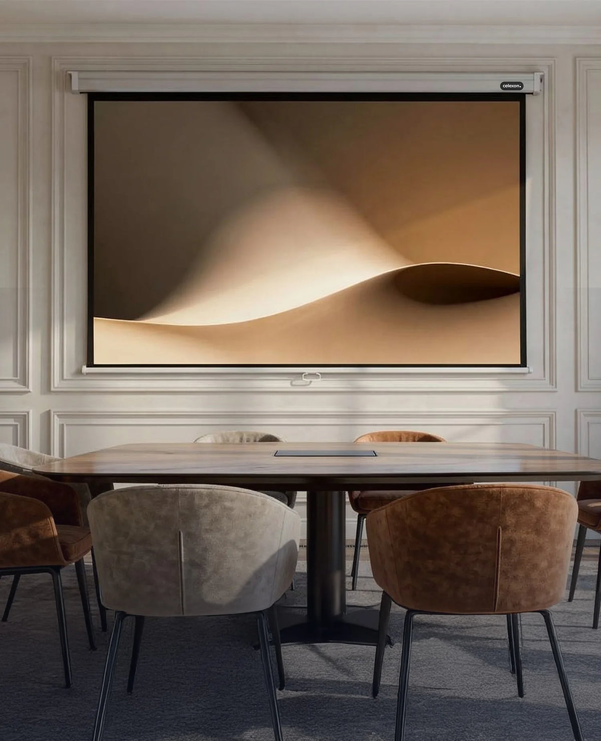 The image shows an elegant, classically furnished conference room with wall paneling, a large table, and upholstered chairs, at the center of which a celexon Manual Professional projector screen displays a calm, abstract projection of softly flowing, sand-colored shapes.